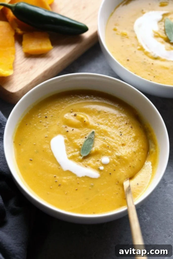 Four bowls of spicy butternut squash soup, some topped with herbs, on a rustic wooden table.