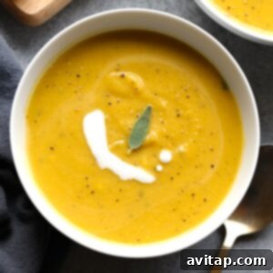 Two bowls of butternut squash soup with sour cream and sage.