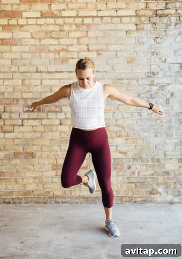 Retreat Lower Body Blast Countdown 2 A woman in activewear smiling during a workout session, embodying the spirit of Healthy Glow Co.