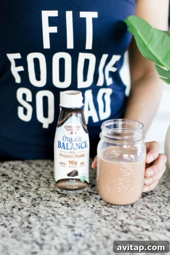A refreshing Organic Balance Dark Chocolate Protein Shake, perfect for post-workout recovery, sits alongside fitness equipment.