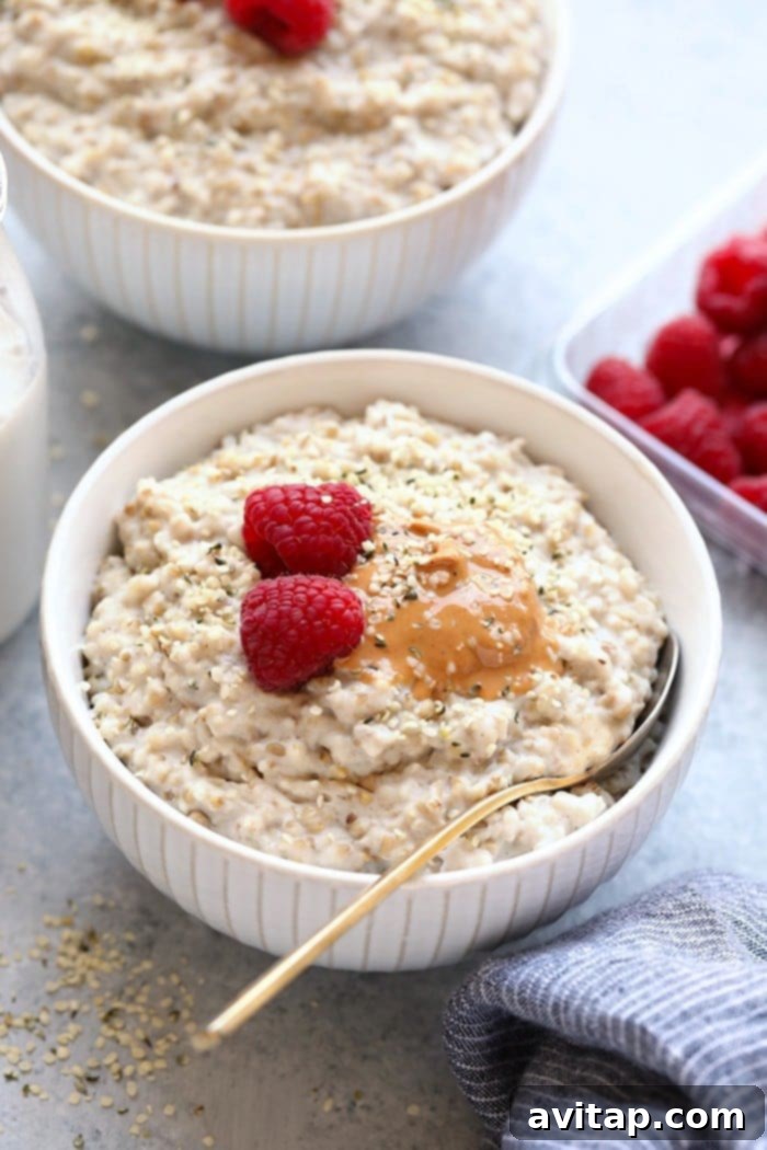 Steel cut oats in bowl with nut butter and raspberries.