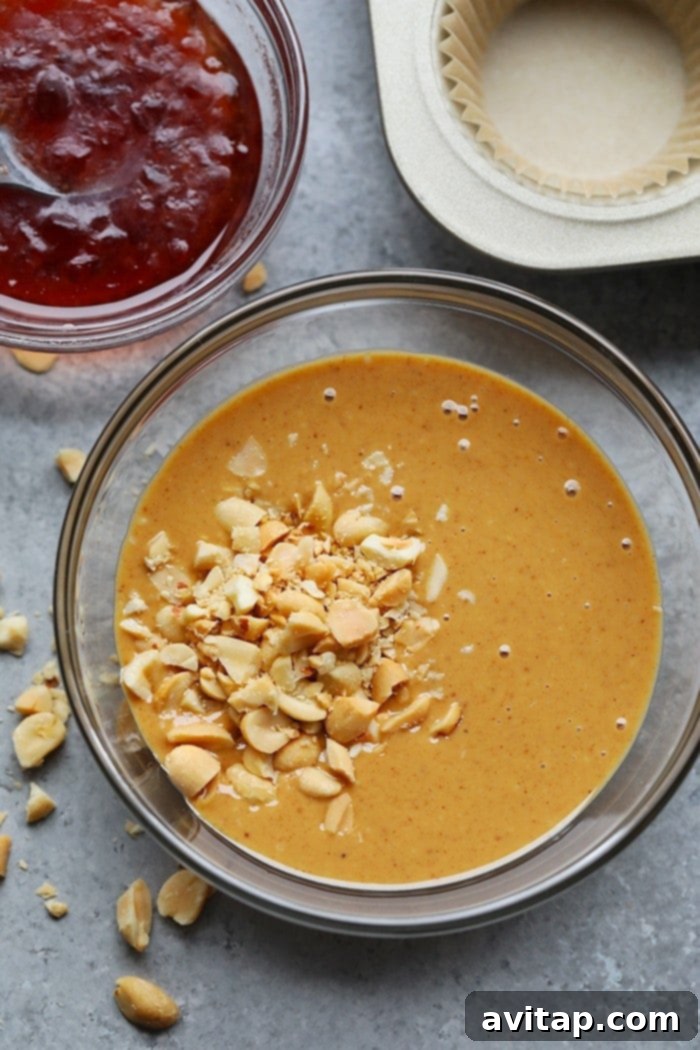 A bowl of creamy peanut butter and jelly fat bomb batter, showcasing its rich, enticing texture before being portioned into individual cups.