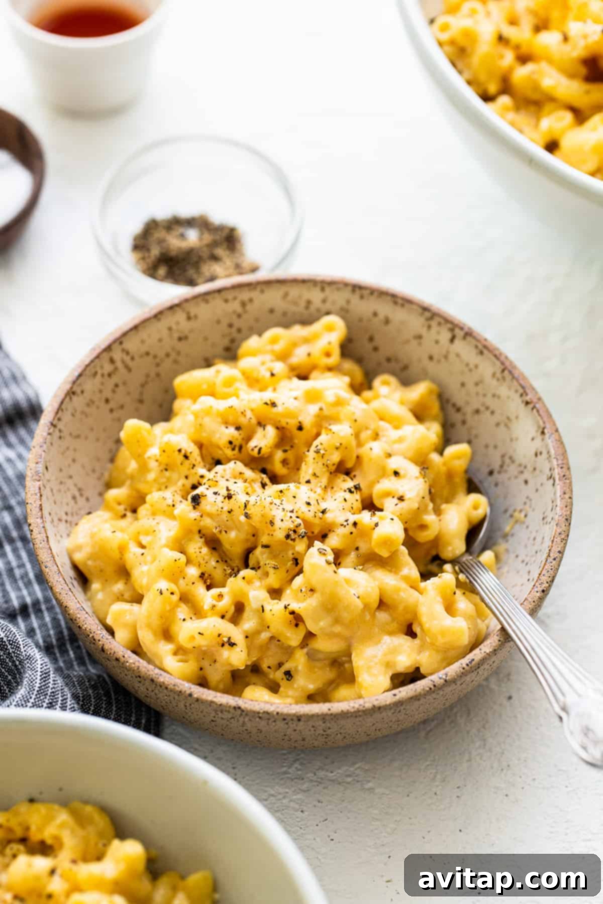 Made with 17g of protein and completely in your Instant Pot, this Protein Mac and Cheese is delicious, creamy, and easy to make! Close-up of protein mac and cheese in a bowl, generously sprinkled with fresh cracked black pepper.