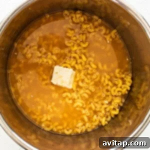 Noodles, butter and broth in the Instant Pot, ready for cooking.