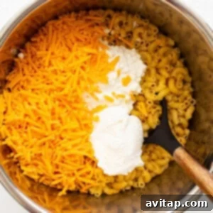 Cheese and cooked noodles being stirred in the Instant Pot.