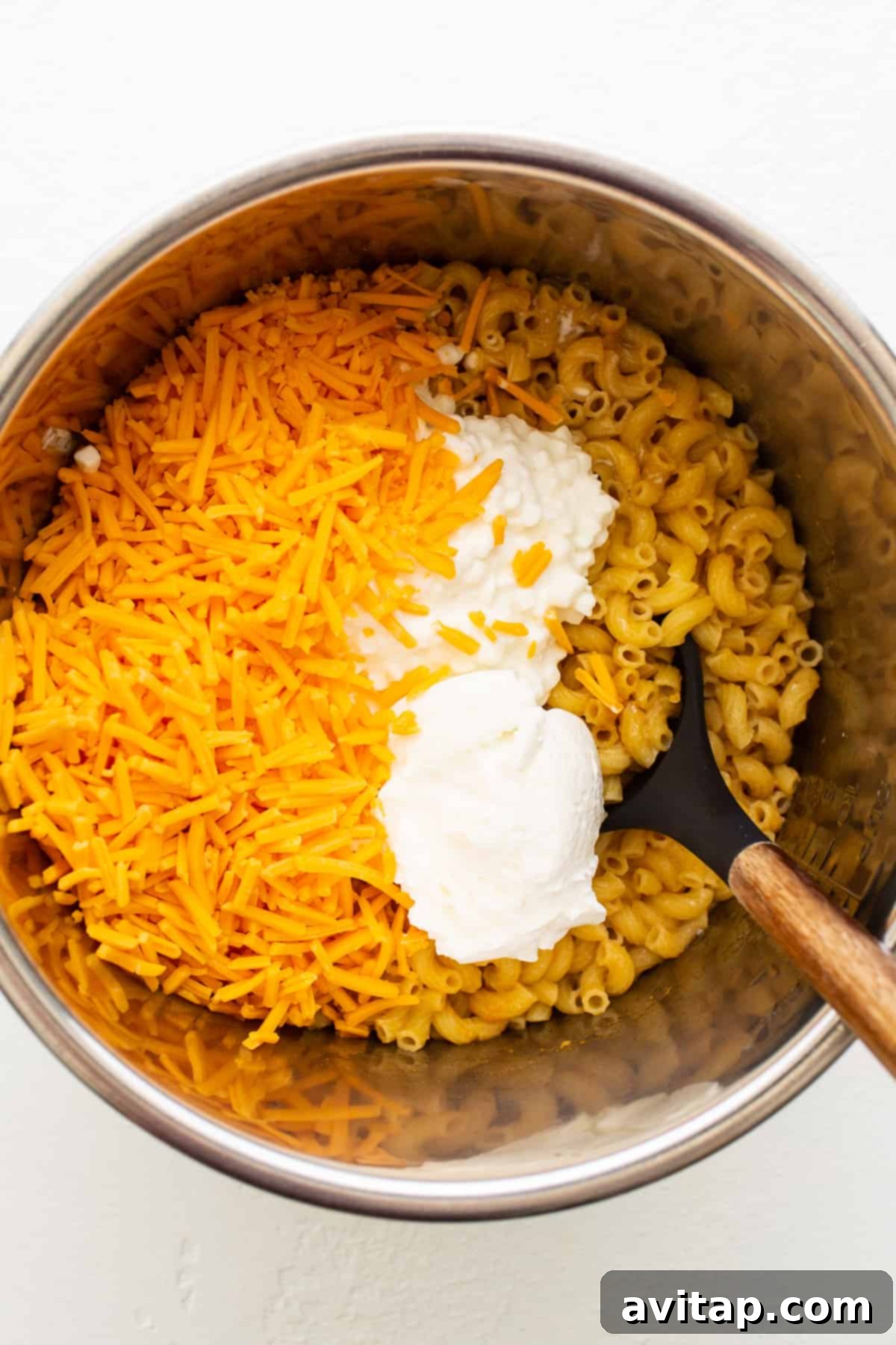 Made with 17g of protein and completely in your Instant Pot, this Protein Mac and Cheese is delicious, creamy, and easy to make! Creamy cheese and cooked elbow noodles being stirred in the Instant Pot liner.