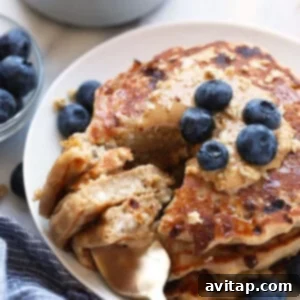 Protein-packed oatmeal pancakes with blueberries on a plate, a healthy and vibrant breakfast option.