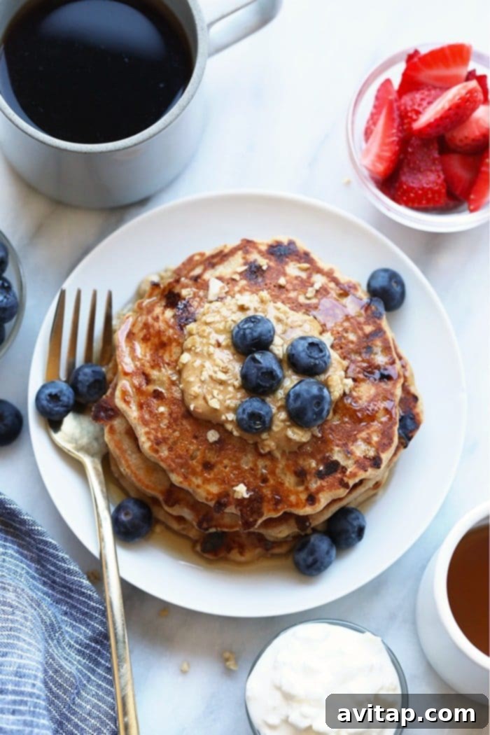 Cottage Cheese Protein Pancake for the win! Who's with me? If you're all about healthy pancakes and getting a protein boost at the same time then you will love this protein pancake recipe! It's made with 100% ground oat flour, cottage cheese, and mashed banana. A stack of protein-packed pancakes beautifully arranged on a plate, topped with a generous dollop of peanut butter, highlighting a nutritious and delicious breakfast option.