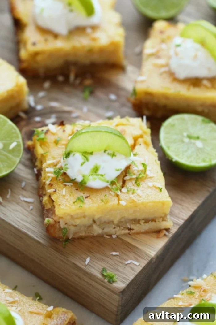 Easy Coconut Key Lime Pie Bars: A Healthy & Refreshing Summer Dessert with Almond Flour Crust Sliced key lime pie bars on a wooden cutting board, garnished with lime wedges and toasted coconut, highlighting their refreshing appeal.