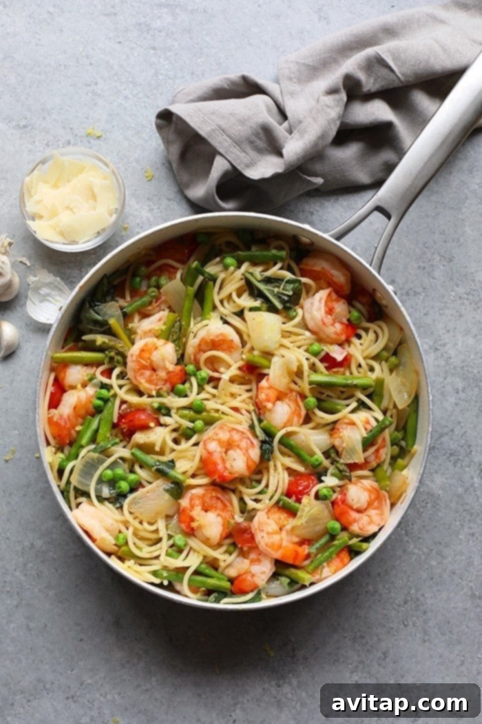 A vibrant plate of Asparagus Shrimp Scampi with lemon wedges and fresh herbs.