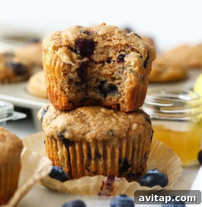 These healthy blueberry muffins are made with 100% whole grains and naturally sweetened with bananas and honey. At only 161 calories per muffin, you're going to love this healthy snack. healthy blueberry muffins stacked
