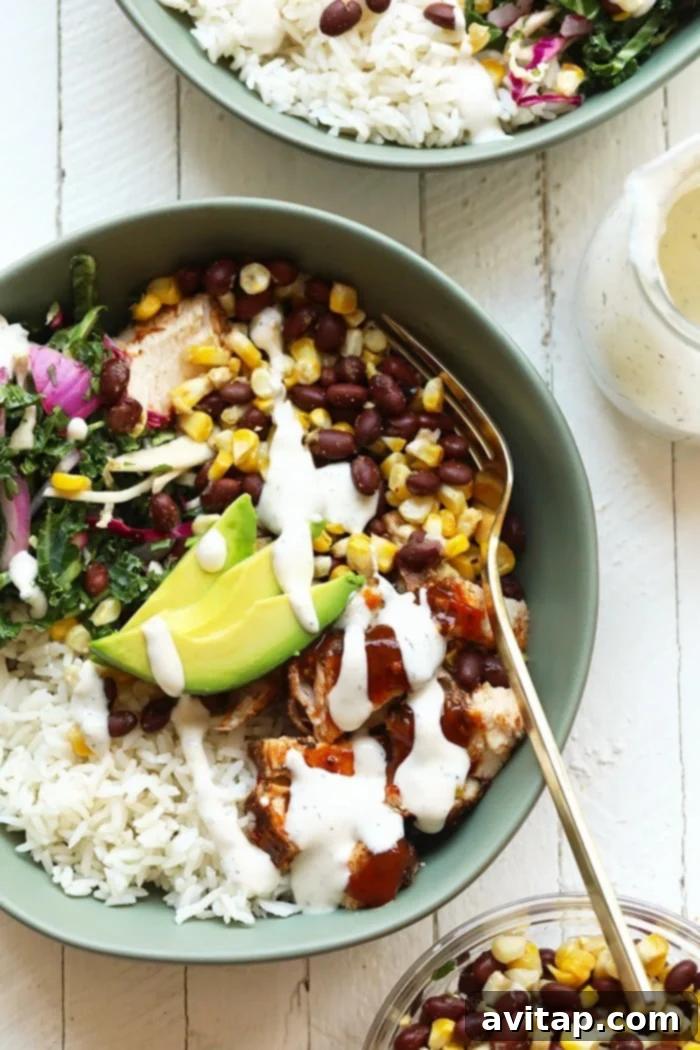 A vibrant and healthy grilled BBQ chicken bowl, featuring grilled corn, black beans, a fresh slaw, and succulent BBQ chicken.
