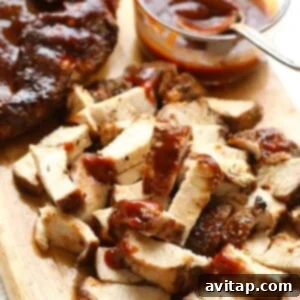 A serving of diced BBQ chicken on a wooden cutting board, ready for assembly.