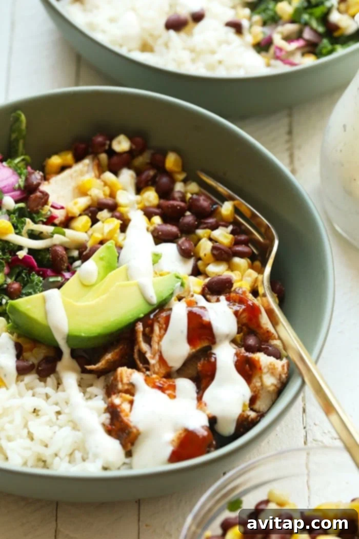 Three beautifully assembled BBQ chicken bowls, drizzled with dressing and ready to be served.