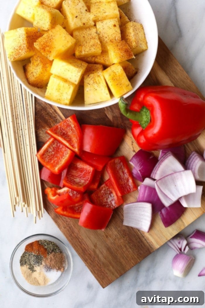 Fresh ingredients for Grilled Pineapple and Jerk Chicken Kebabs, including pineapple, peppers, onions, and chicken