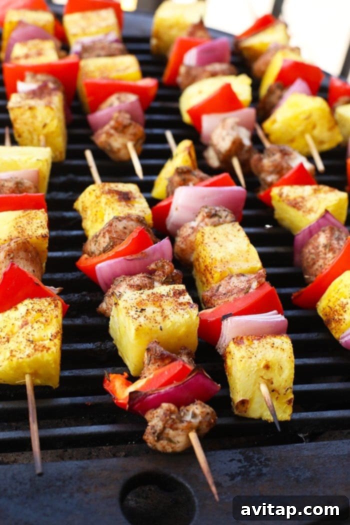 Grilled Pineapple and Jerk Chicken Kebabs cooking on an outdoor grill