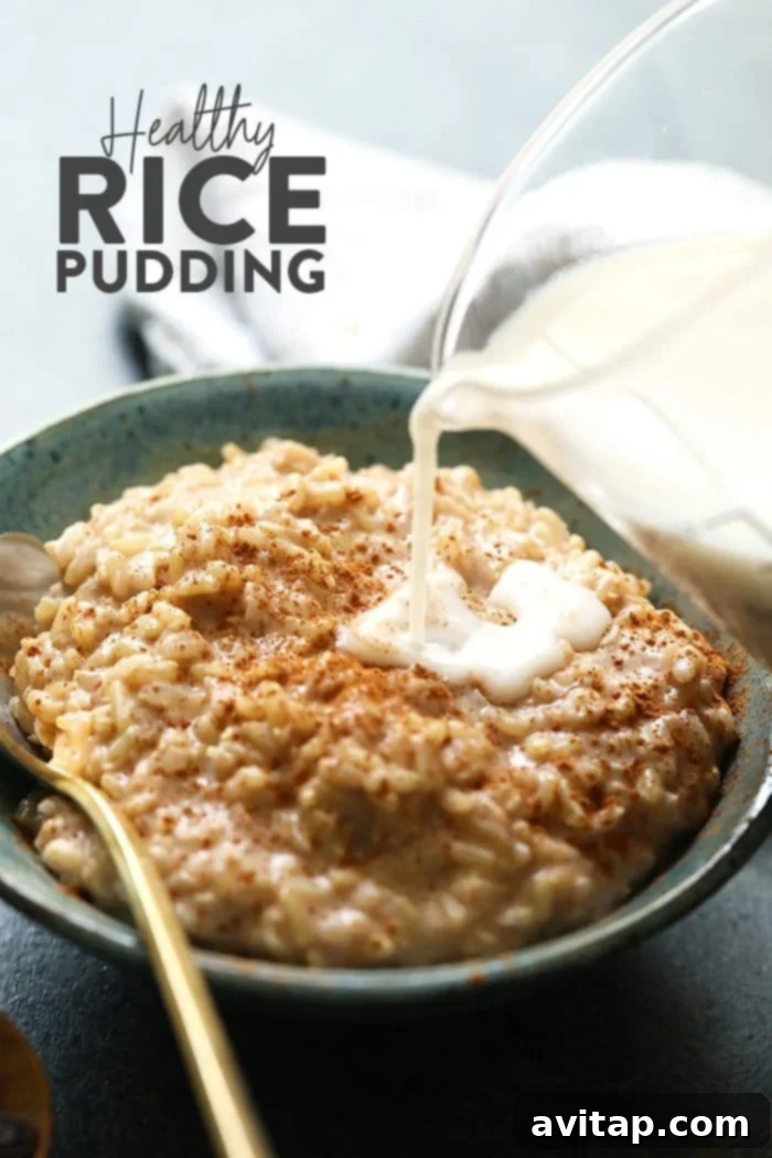 A single serving bowl of brown rice pudding, ready to be eaten, with a spoon nearby, emphasizing its comfort and accessibility.