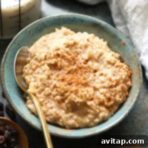 A top-down view of a bowl of healthy brown rice pudding, garnished with a sprinkle of cinnamon, suggesting a warm and delicious meal.