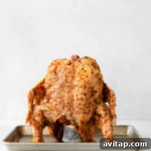 a beer can chicken roasting on a tray.