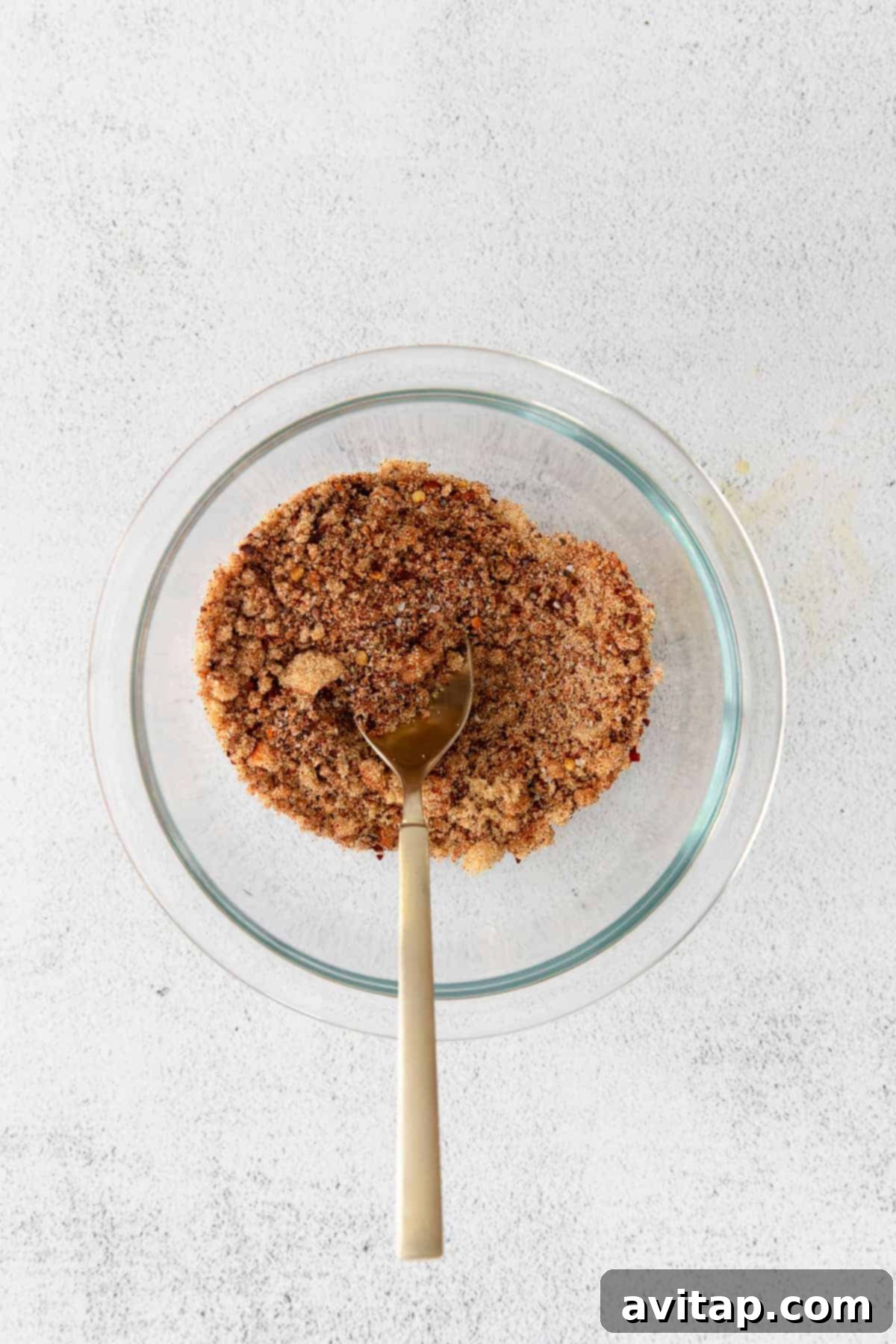 Homemade Dry Rub for Juicy Chicken A glass bowl filled with a homemade sweet and smoky dry rub, ready for seasoning.