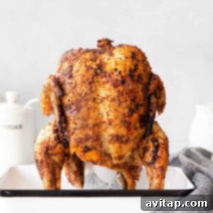A beer can chicken on a baking sheet, golden and crispy.