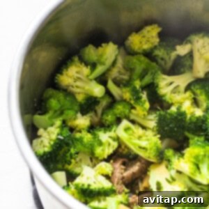 Vibrantly green broccoli, perfectly cooked and nestled among the beef in the Instant Pot, just before the sauce thickening step.