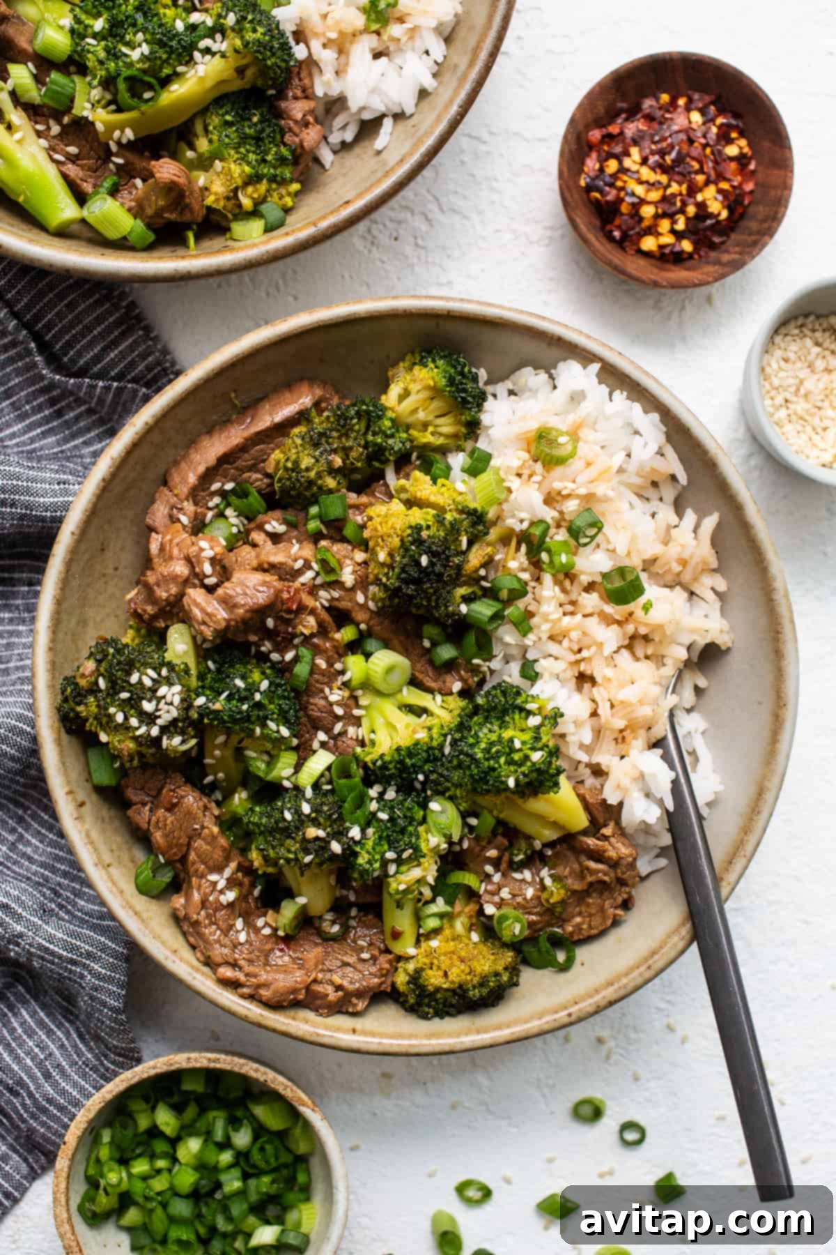 A delightful bowl of Instant Pot Beef and Broccoli stir fry, perfectly plated and ready to be served, garnished with sesame seeds.