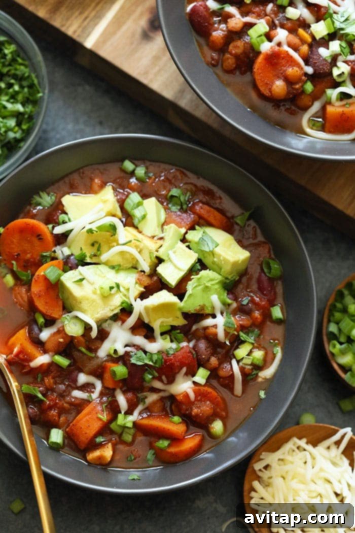 Vegetarian Instant Pot chili served in a rustic ceramic bowl, garnished with fresh cilantro and vibrant avocado slices, highlighting its rich texture and appealing presentation.