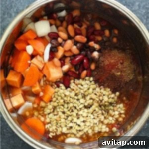 An Instant Pot filled with a colorful mix of beans, lentils, carrots, sweet potatoes, diced tomatoes, and spices, ready to be cooked into a delicious and hearty chili.