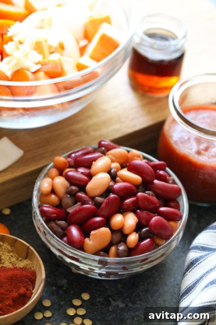 Assorted beans including black beans, kidney beans, and pinto beans in a clean white bowl, freshly rinsed and ready to be added to the Instant Pot for chili preparation.