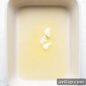 Butter melting in a clear glass baking dish as the oven preheats.
