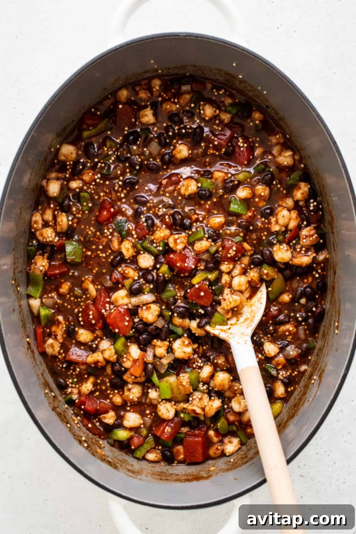 Hearty black bean quinoa chili simmering gently in a large Dutch oven on the stovetop, its rich flavors melding together.
