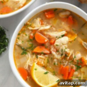 two bowls of chicken soup on a marble table.