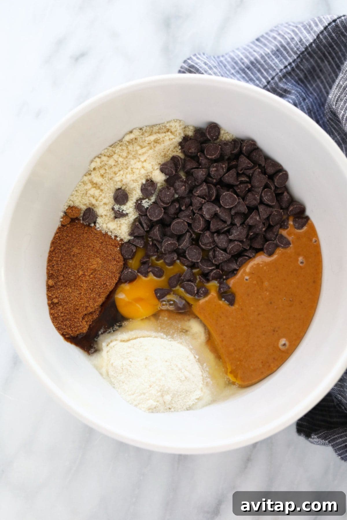 Ingredients for healthy peanut butter cookies mixed in a bowl, showing the dough's perfect consistency.