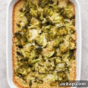 A white baking dish with broccoli casserole, featuring browned edges and a creamy texture.
