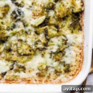 Broccoli and cheese bake in a white rectangular dish, with melted cheese and browned edges.