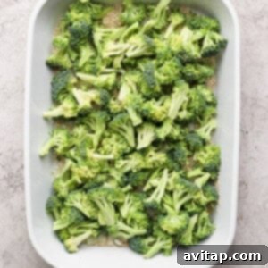 A baking dish filled with raw broccoli florets ready for cooking.
