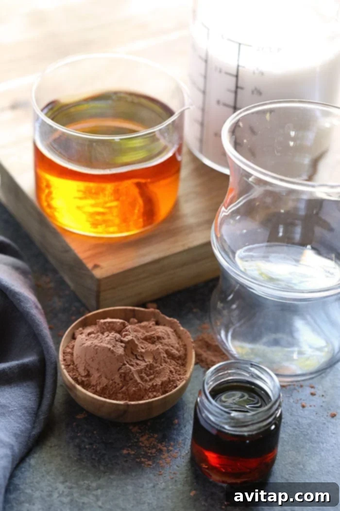 Key ingredients for dairy-free hot chocolate, including almond milk, cocoa, maple syrup, and amaretto