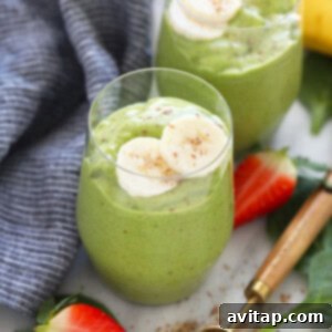 Two glasses of green smoothie with bananas and strawberries.