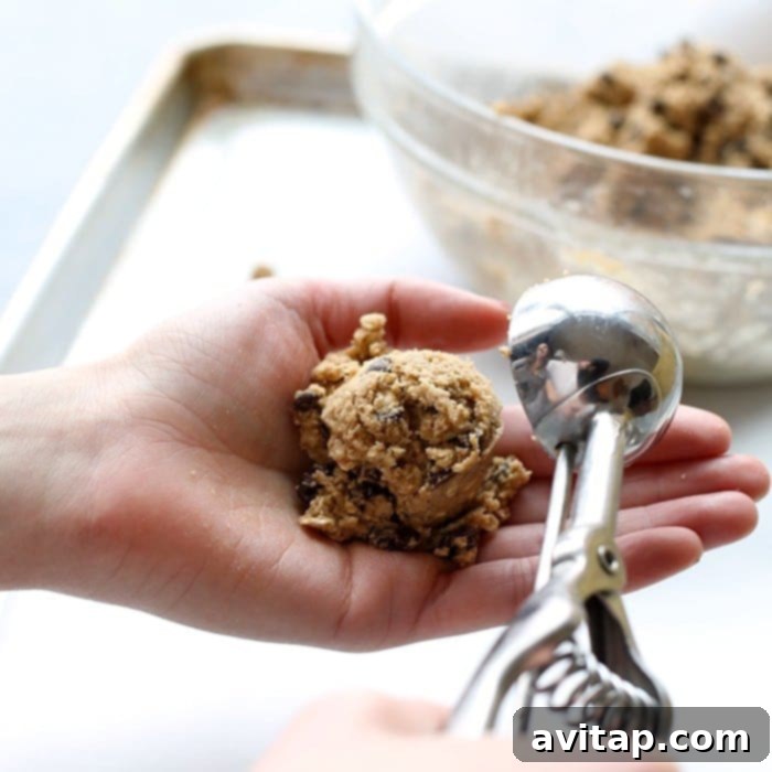 Ideal portions of oatmeal cookie dough for baking delicious treats. A scoop of healthy oatmeal cookie dough on a spoon, perfectly portioned and ready for baking.