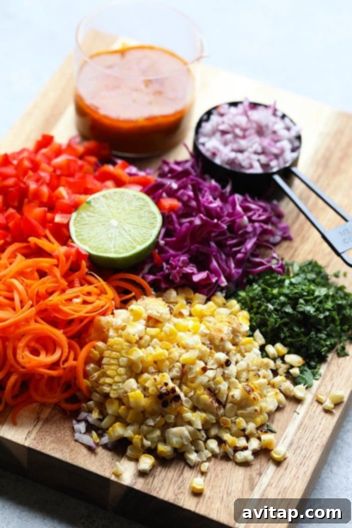 A vibrant display of fresh ingredients, including corn, carrots, red pepper, and cilantro, ready to be transformed into our zesty Thai Chili Summer Corn Salad. Fresh, colorful ingredients for corn salad neatly arranged on a wooden cutting board.