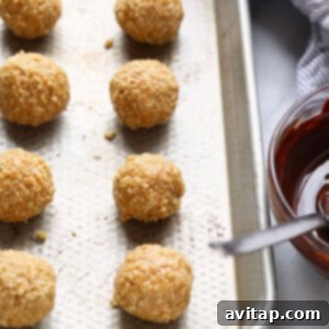 Granola bites on a baking sheet with a bowl of dipping sauce.