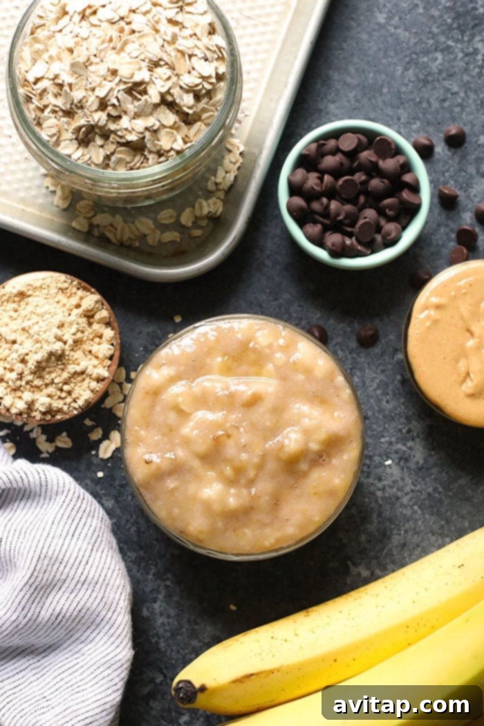 A vibrant flat lay photo of fresh ingredients for vegan cookies, including ripe bananas, rolled oats, jars of peanut butter and flax seeds, and dark chocolate chips. All ingredients are whole and healthy.
