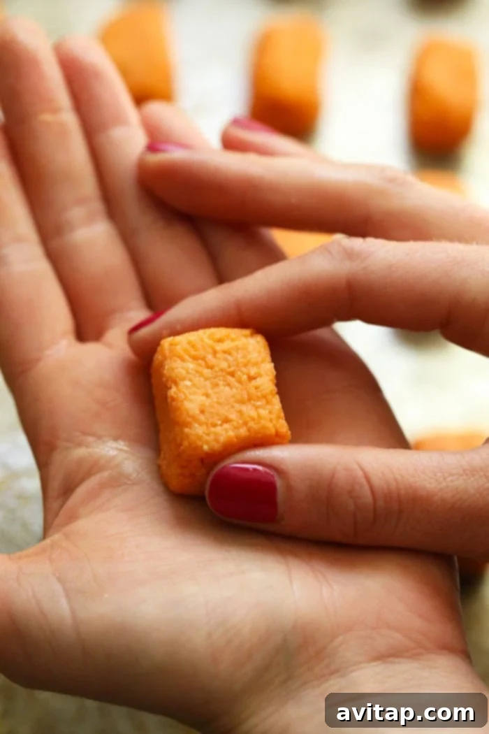 Hands meticulously forming a sweet potato tater tot, showcasing the easy shaping process.