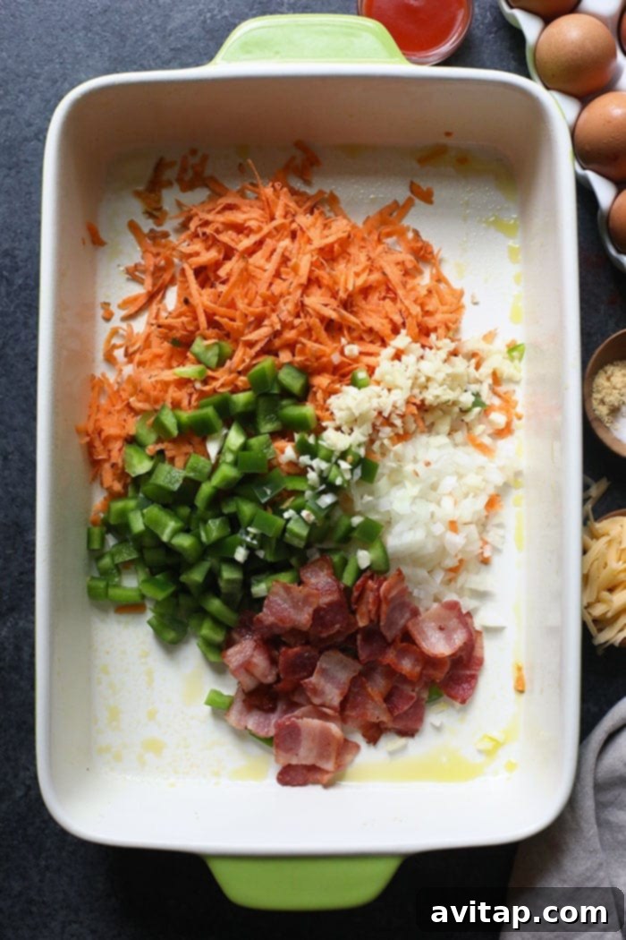 All the wholesome ingredients for a Sweet Potato Hash Breakfast Casserole, meticulously arranged in a casserole dish before baking.