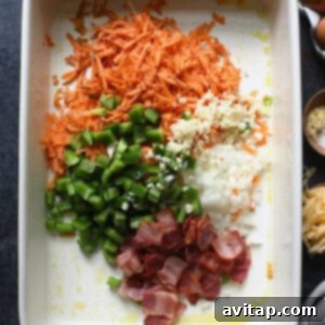 Healthy breakfast casserole with eggs, carrots, bacon, and other ingredients, assembled in a dish.