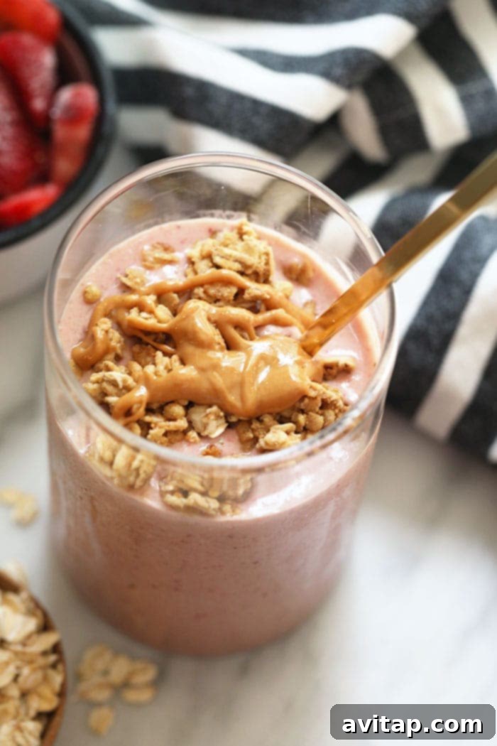 Delicious healthy breakfast smoothie with peanut butter drizzle. A glass of healthy breakfast smoothie garnished with a drizzle of peanut butter, a perfect morning meal.