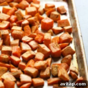 Healthy roasted sweet potatoes on a baking sheet, golden and tender, ready for mashing.
