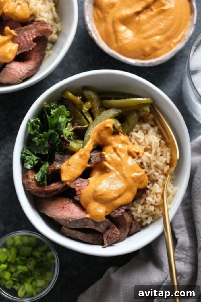 Healthy Philly Cheese Steak Meal Prep Bowls, top-down view with flank steak, peppers, onions, brown rice, and kale.
