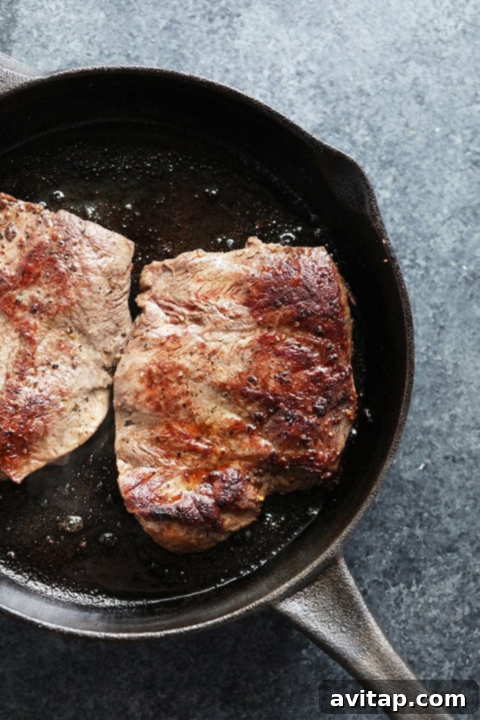 Close-up of freshly seared flank steak, sliced thinly against the grain, ready for meal prep.